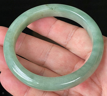 Close-up of fine crystalline texture and vivid imperial green hues on icy apple green jadeite bangle