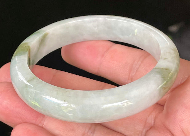 Close-up of fine crystalline texture and beautiful moss green swirls on icy apple green and white jadeite bangle