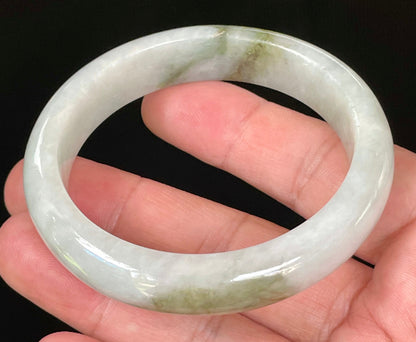 Close-up of fine crystalline texture and beautiful moss green swirls on icy apple green and white jadeite bangle