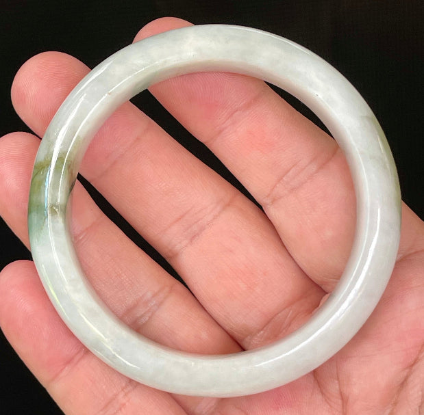 Close-up of fine crystalline texture and beautiful moss green swirls on icy apple green and white jadeite bangle