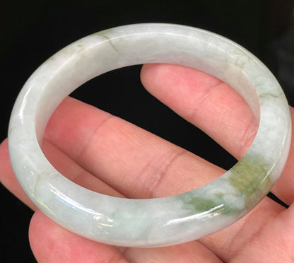 Close-up of fine crystalline texture and beautiful moss green swirls on icy apple green and white jadeite bangle