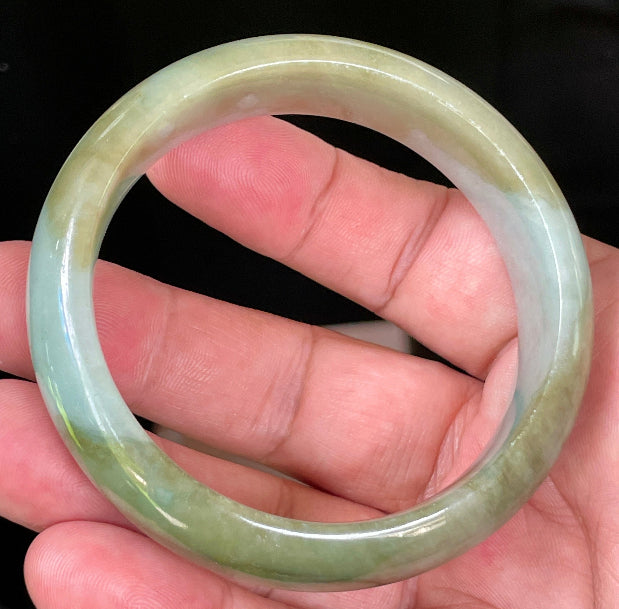 Close-up of fine crystalline texture and serene moss green hues on icy apple green and bluish white jadeite bangle