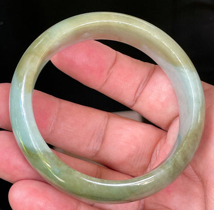 Close-up of fine crystalline texture and serene moss green hues on icy apple green and bluish white jadeite bangle