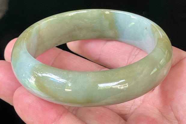 Close-up of fine crystalline texture and serene moss green hues on icy apple green and bluish white jadeite bangle