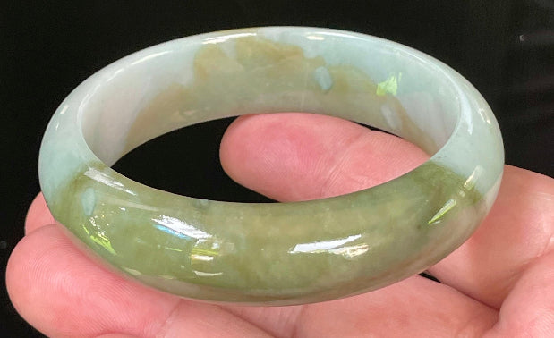 Close-up of fine crystalline texture and serene moss green hues on icy apple green and bluish white jadeite bangle