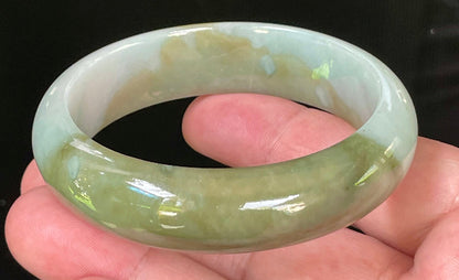 Close-up of fine crystalline texture and serene moss green hues on icy apple green and bluish white jadeite bangle