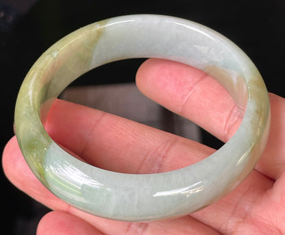 Close-up of fine crystalline texture and serene moss green hues on icy apple green and bluish white jadeite bangle