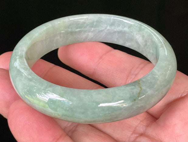 Close-up of fine crystalline texture and bluish apple green hues on icy greyish white jadeite bangle