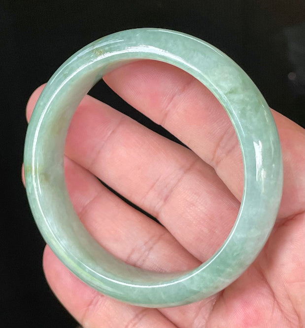 Close-up of fine crystalline texture and bluish apple green hues on icy greyish white jadeite bangle