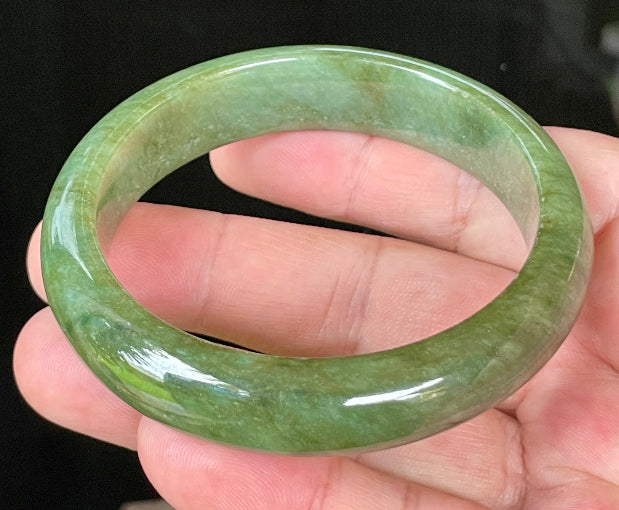 Close-up of fine crystalline texture and vibrant apple green hues on icy emerald jadeite bangle
