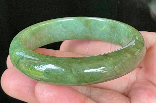 Close-up of fine crystalline texture and vibrant apple green hues on icy emerald jadeite bangle
