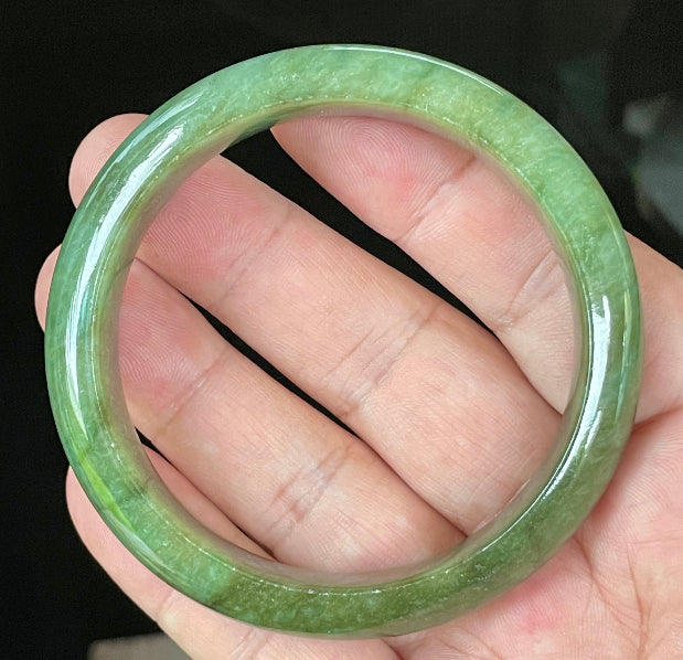 Close-up of fine crystalline texture and vibrant apple green hues on icy emerald jadeite bangle