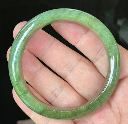 Close-up of fine crystalline texture and vibrant apple green hues on icy emerald jadeite bangle