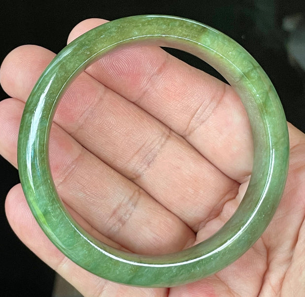 Close-up of fine crystalline texture and vibrant apple green hues on icy emerald jadeite bangle