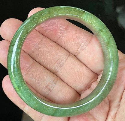 Close-up of fine crystalline texture and vibrant apple green hues on icy emerald jadeite bangle