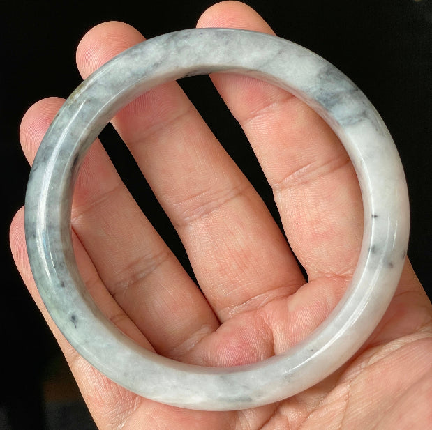 Close-up of fine crystalline texture and subtle honey hues on icy grey and milky white jadeite bangle