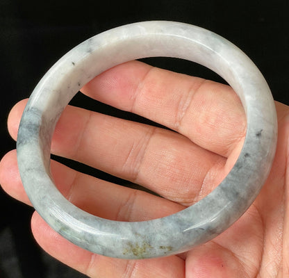 Close-up of fine crystalline texture and subtle honey hues on icy grey and milky white jadeite bangle