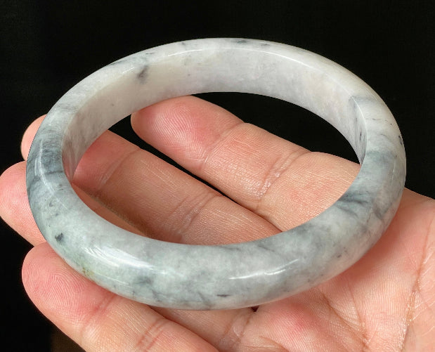 Close-up of fine crystalline texture and subtle honey hues on icy grey and milky white jadeite bangle