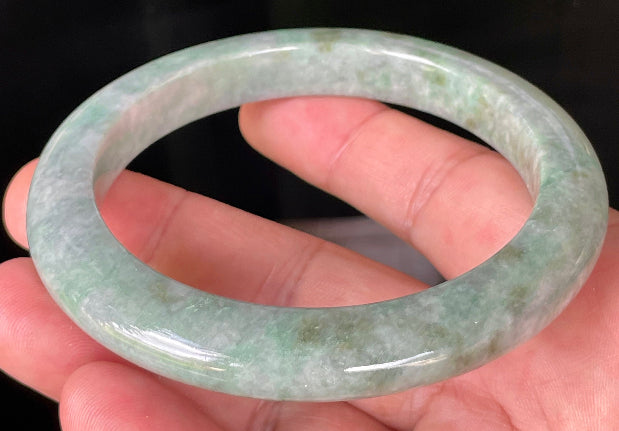 Close-up of fine crystalline texture and imperial green hues on icy greyish apple green jadeite bangle
