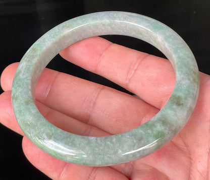 Close-up of fine crystalline texture and imperial green hues on icy greyish apple green jadeite bangle