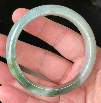 Close-up of fine crystalline texture and apple green hues on icy greyish white jadeite bangle