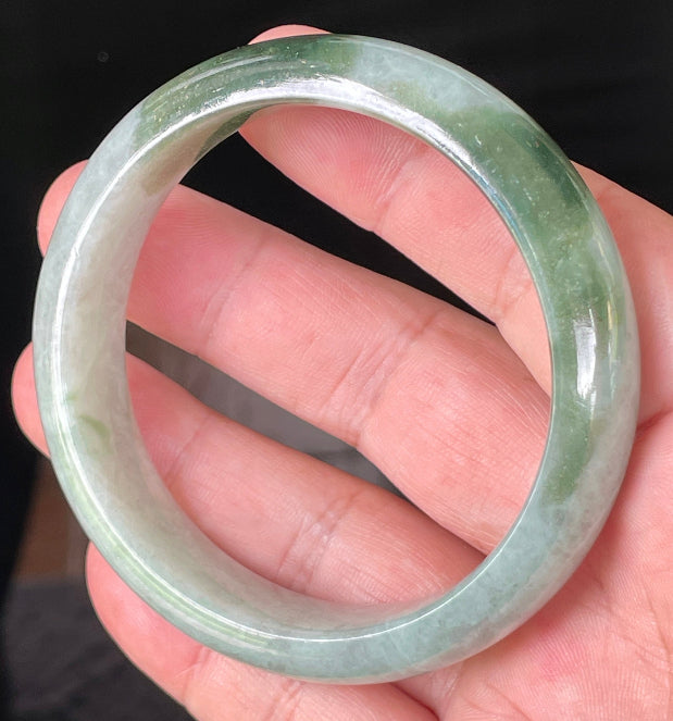 Close-up of fine crystalline texture and apple green hues on icy greyish white jadeite bangle