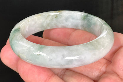 Close-up of fine crystalline texture and moss in the snow effect on rare icy greyish white and imperial green jadeite bangle