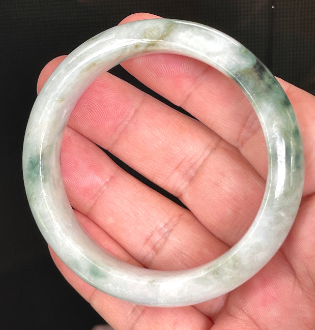 Close-up of fine crystalline texture and moss in the snow effect on rare icy greyish white and imperial green jadeite bangle