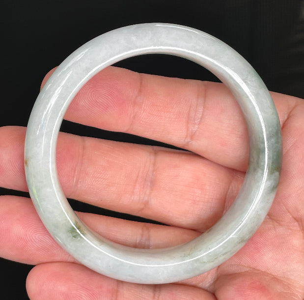 Close-up of fine crystalline texture and moss in the snow effect on rare icy greyish white and imperial green jadeite bangle