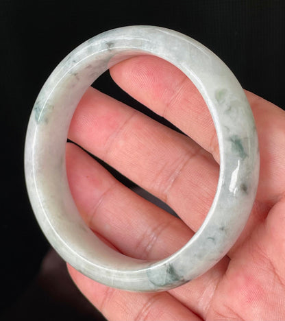 Close-up of fine crystalline texture and moss in the snow effect on greyish milky white and green jadeite bangle
