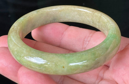 Close-up of fine crystalline texture and honey brown hues on icy green jadeite bangle