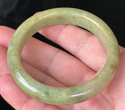 Close-up of fine crystalline texture and honey brown hues on icy green jadeite bangle