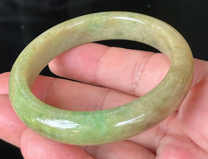 Close-up of fine crystalline texture and honey brown hues on icy green jadeite bangle