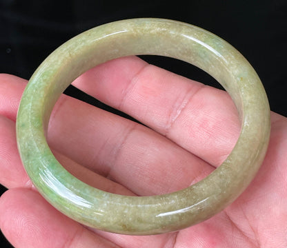 Close-up of fine crystalline texture and honey brown hues on icy green jadeite bangle