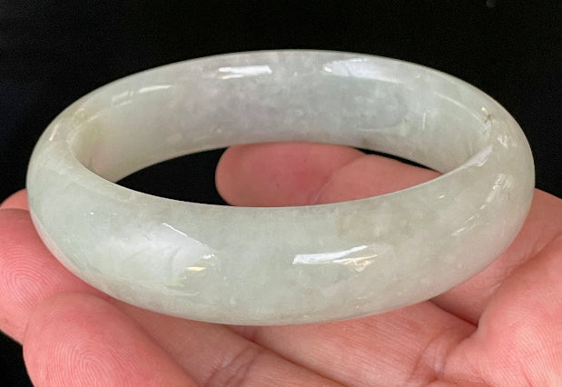 Close-up of fine crystalline texture and a striking imperial green line on very icy apple green jadeite bangle