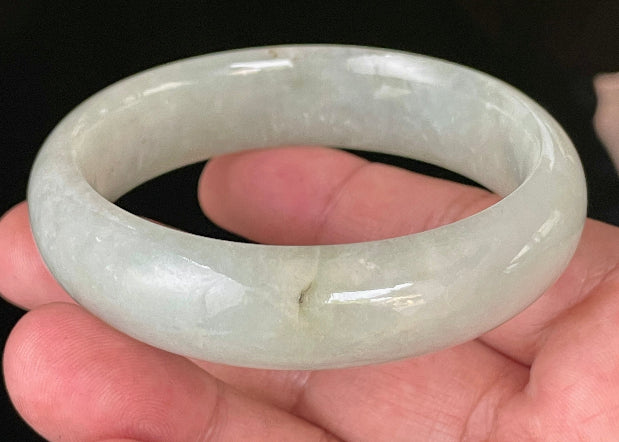 Close-up of fine crystalline texture and a striking imperial green line on very icy apple green jadeite bangle