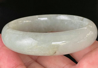 Close-up of fine crystalline texture and a striking imperial green line on very icy apple green jadeite bangle