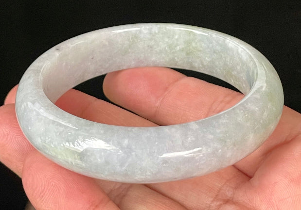Close-up of fine crystalline texture and apple green hues on icy light lavender and white jadeite bangle