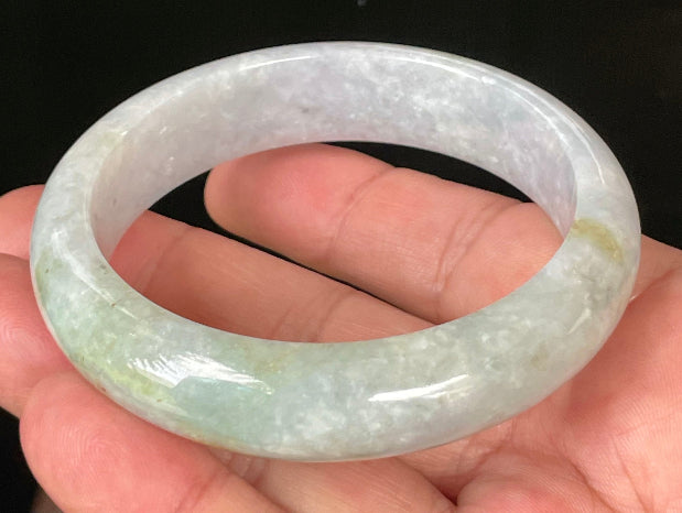 Close-up of fine crystalline texture and apple green hues on icy light lavender and white jadeite bangle