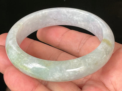 Close-up of fine crystalline texture and apple green hues on icy light lavender and white jadeite bangle