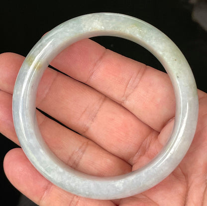 Close-up of fine crystalline texture and apple green hues on icy light lavender and white jadeite bangle