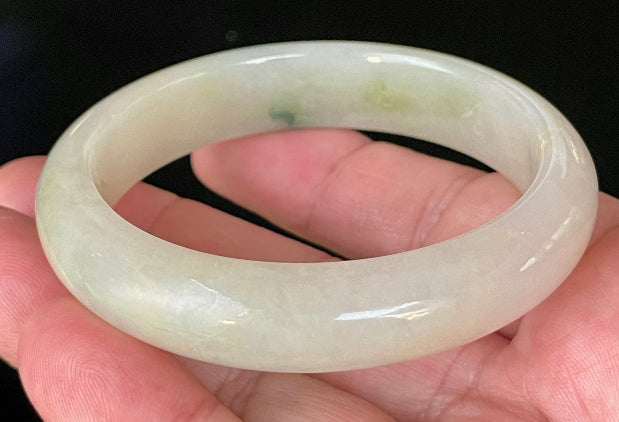 Close-up of fine crystalline texture and natural stone vines on icy yellow and white jadeite bangle
