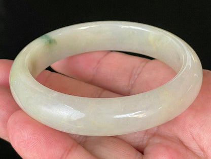 Close-up of fine crystalline texture and natural stone vines on icy yellow and white jadeite bangle
