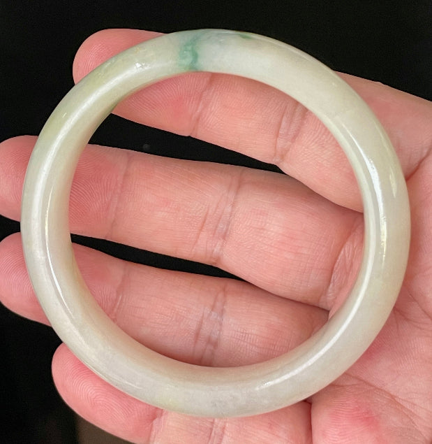 Close-up of fine crystalline texture and natural stone vines on icy yellow and white jadeite bangle