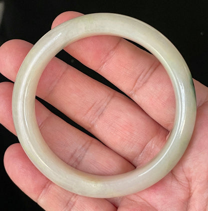 Close-up of fine crystalline texture and natural stone vines on icy yellow and white jadeite bangle