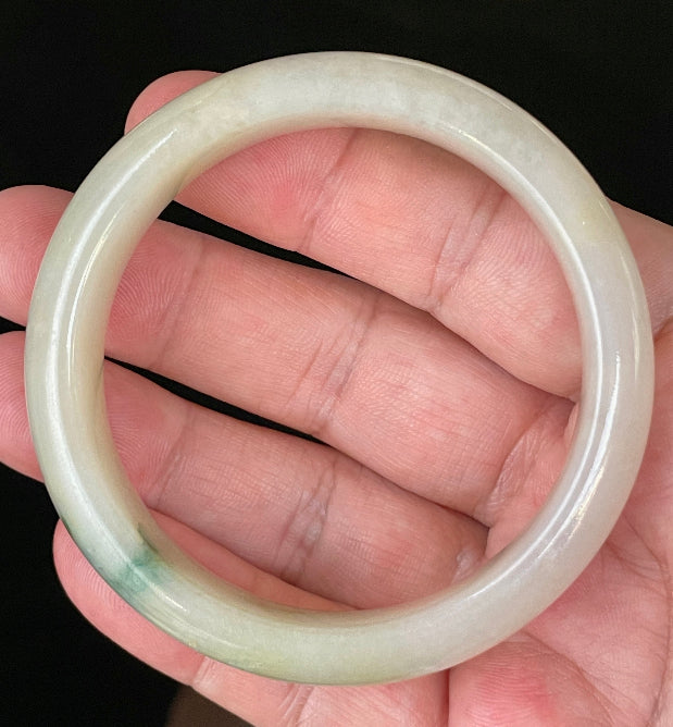Close-up of fine crystalline texture and natural stone vines on icy yellow and white jadeite bangle