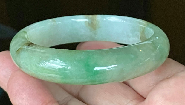 Close-up of fine crystalline texture and imperial green hues on icy bluish white jadeite bangle