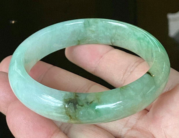 Close-up of fine crystalline texture and imperial green hues on icy bluish white jadeite bangle