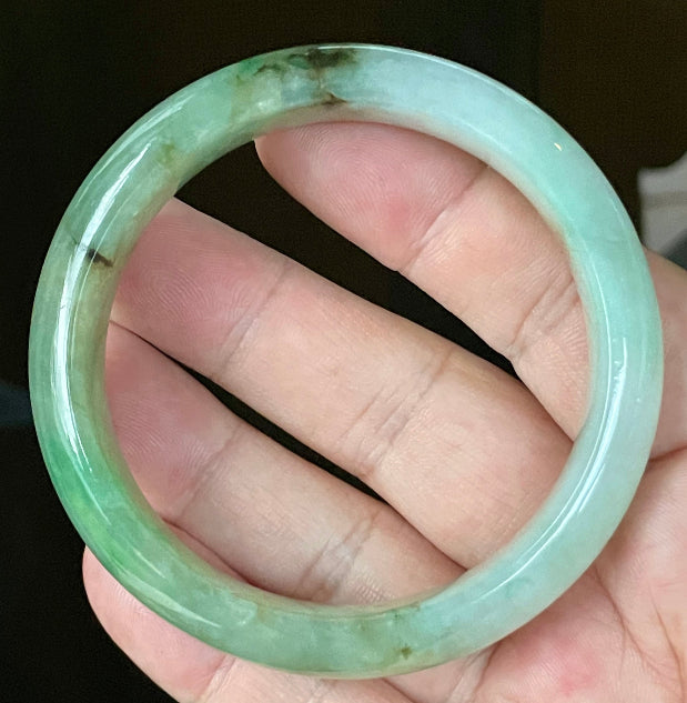 Close-up of fine crystalline texture and imperial green hues on icy bluish white jadeite bangle