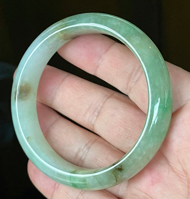 Close-up of fine crystalline texture and imperial green hues on icy bluish white jadeite bangle